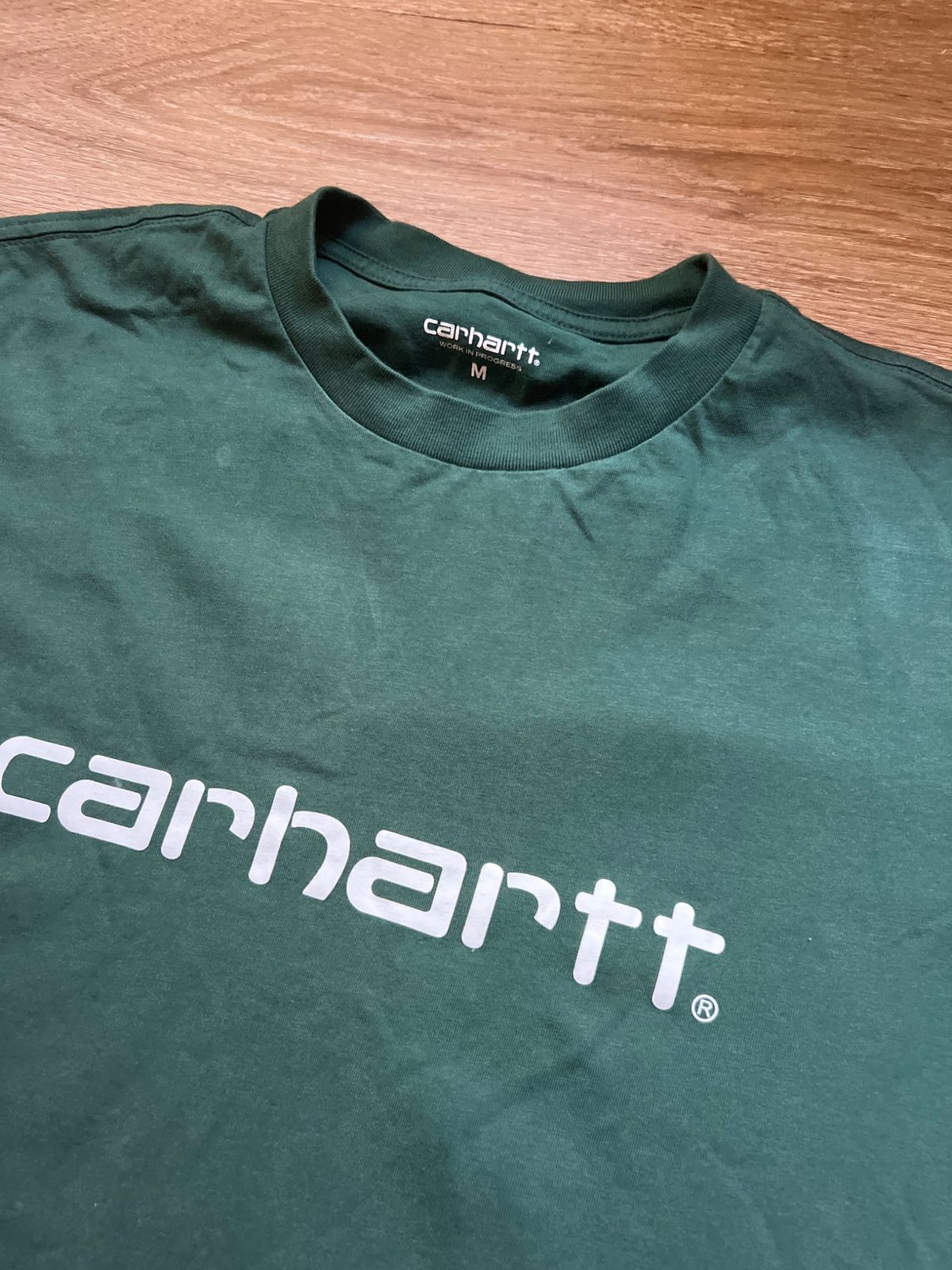 The label and collar of the green Carhartt T-shirt