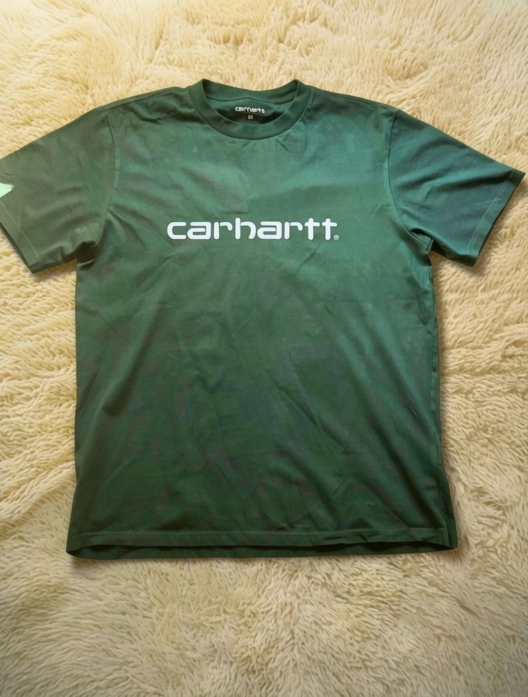 The green T-shirt on the light rug, with warm, soft light